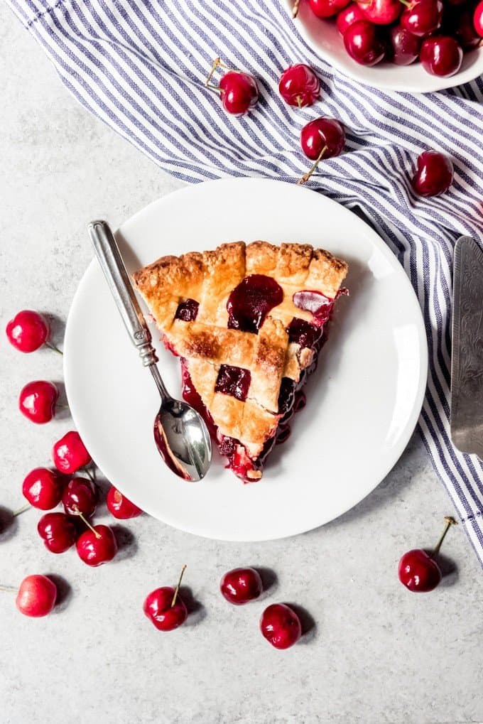 An image of a slice of homemade cherry pie on a plate.