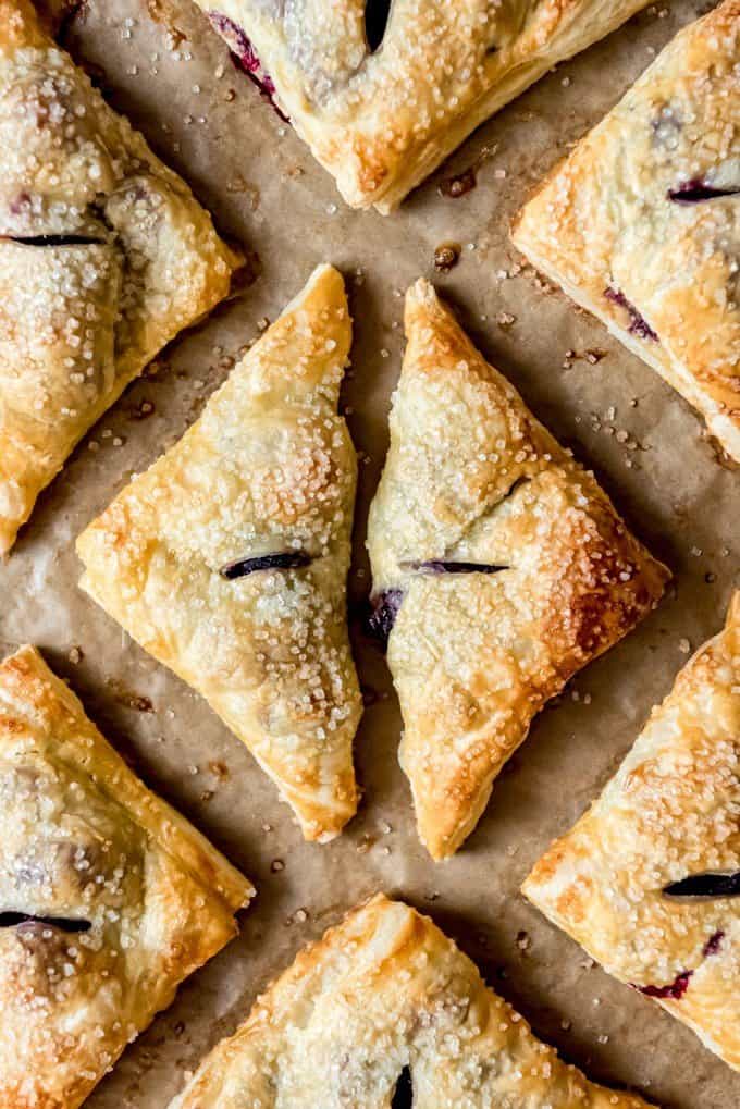 An image of blackberry turnovers with puff pastry on a baking sheet.