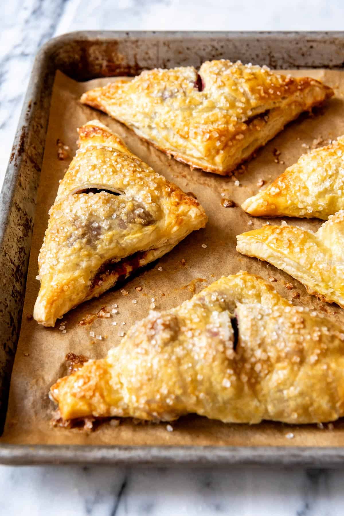 An image of blackberry turnovers sprinkled with coarse sugar.