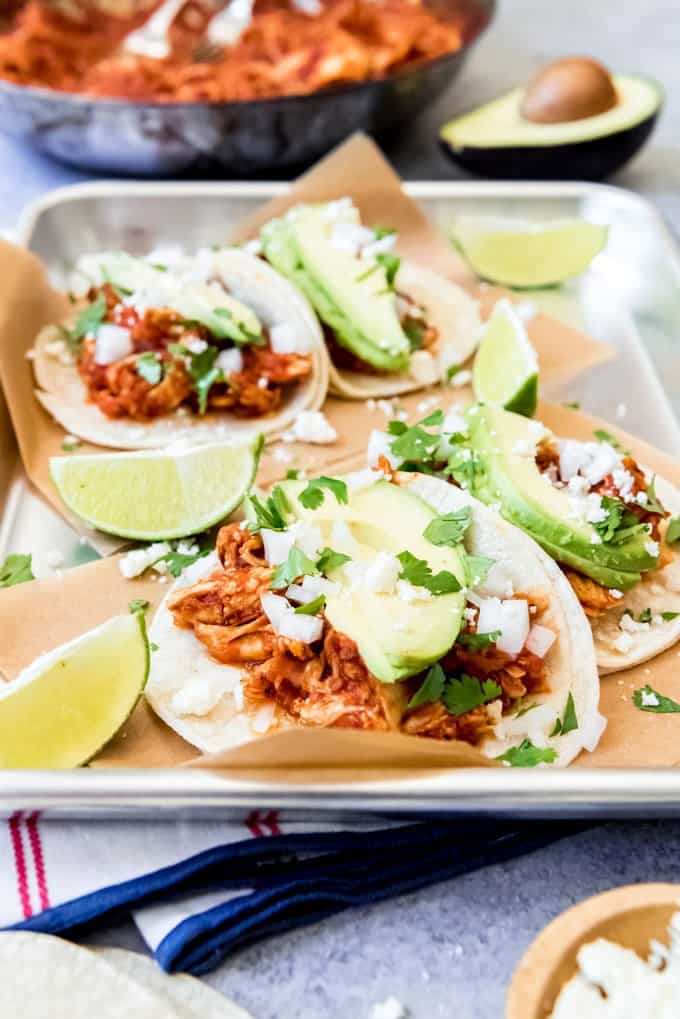An image of shredded chicken tacos on a tray.