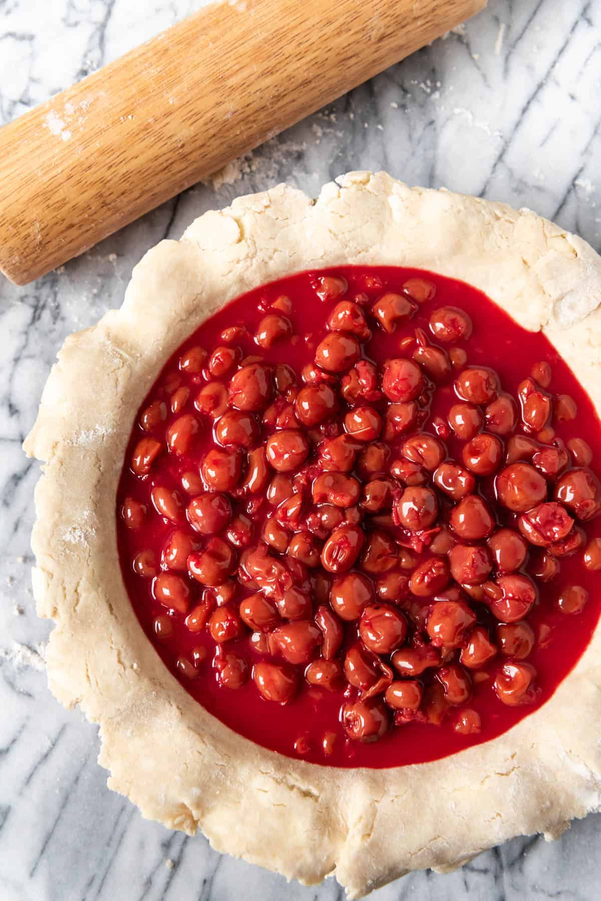 Homemade cherry pie filling in an unbaked pie crust.