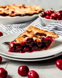 An image of a slice of homemade cherry pie on a plate.