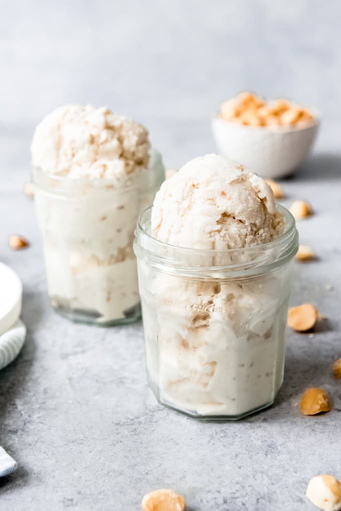 An image of two glass jars with scoops of homemade coconut macadamia nut ice cream in them.