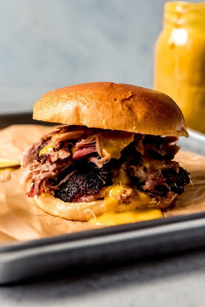 An image of a smoked pulled pork sandwich with Carolina gold barbecue sauce.