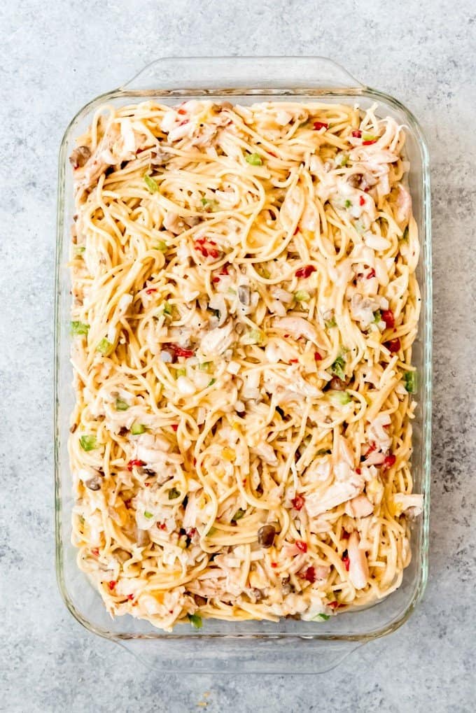An image of an unbaked chicken spaghetti casserole before being topped with cheese and baked in the oven.