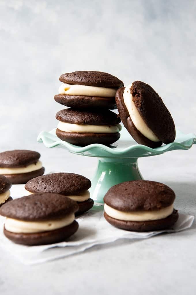 An image of chocolate salted caramel whoopie pies stacked on a cake stand.