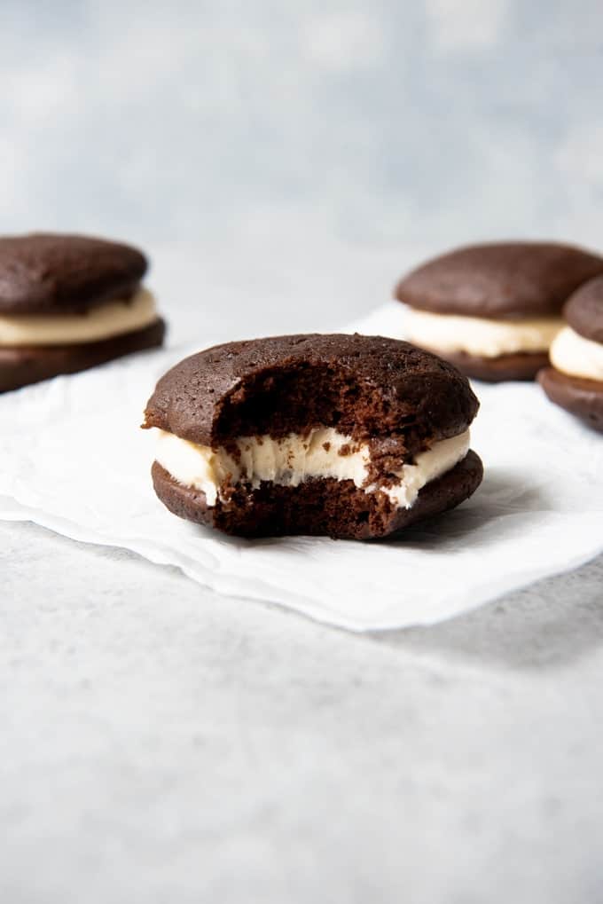 An image of a chocolate salted caramel whoopie pie with a bite taken out of it showcasing the soft texture.