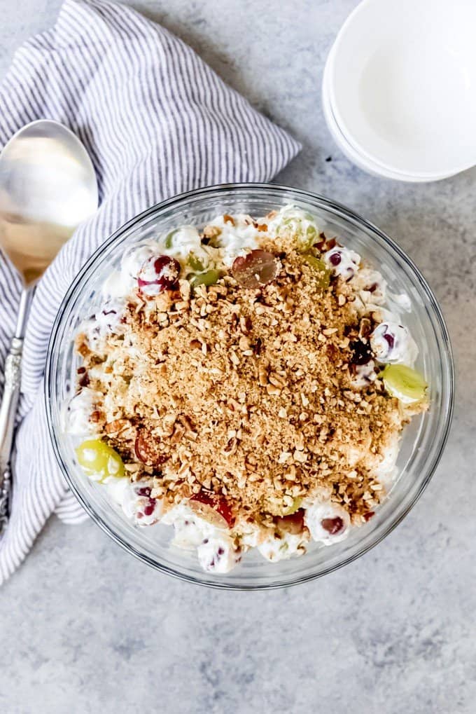 An image of a large bowl of creamy grape salad with a brown sugar pecan streusel type topping.