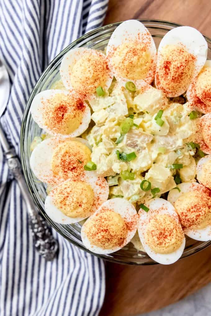 An image of creamy potato salad with eggs and mayo, decorated with deviled eggs on top.