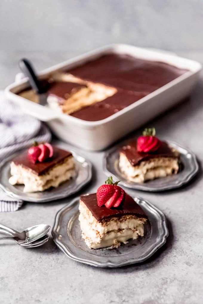 An image of three slices of chocolate eclair cake on dessert plates.