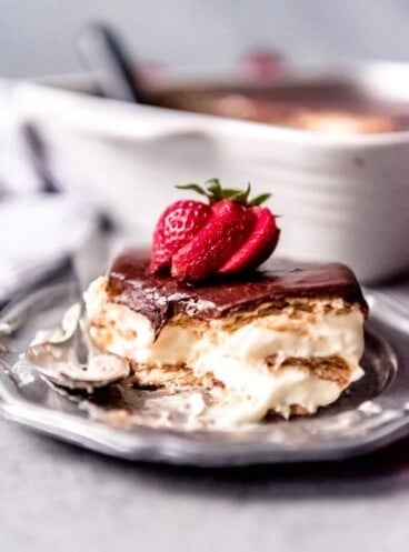 An image of a piece of no-bake chocolate eclair cake with a sliced strawberry on top.