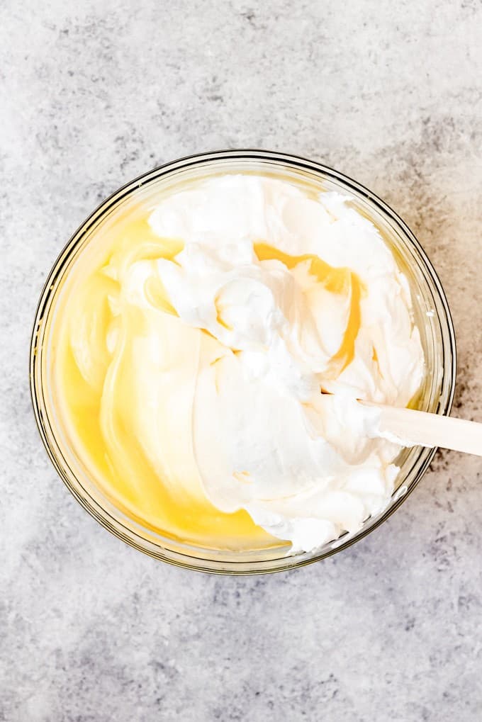 An image of whipped cream being folded into vanilla pudding.
