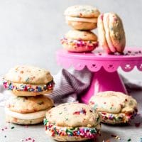 An image of funfetti whoopie pies stacked on a pink cake stand.