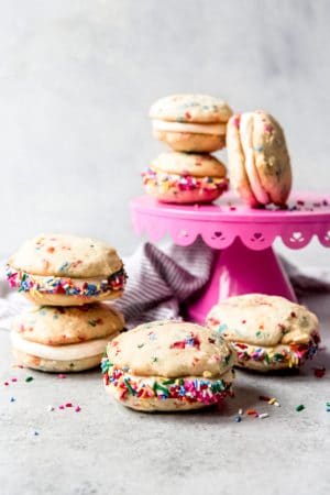 An image of funfetti whoopie pies stacked on a pink cake stand.