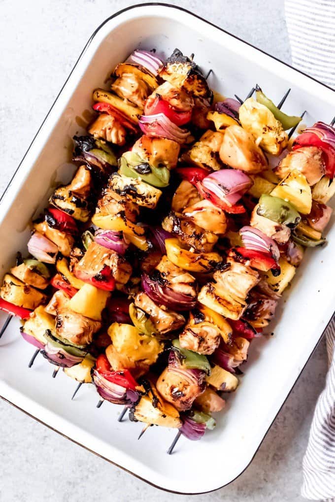 An image of grilled Hawaiian Teriyaki Chicken Skewers in a white baking dish.