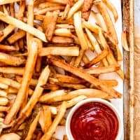 An image of double-fried french fries with ketchup.