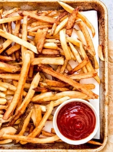 An image of double-fried french fries with ketchup.