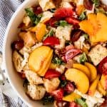 Peach Panzanella Salad is an easy summer salad recipe that is loaded with fresh flavors of heirloom tomatoes, basil leaves, mozzarella, juicy ripe peaches, and torn crusty bread with a simple honey dijon vinaigrette!  It's perfect for potlucks, picnics, light summer dinners and easy no-fuss lunches!