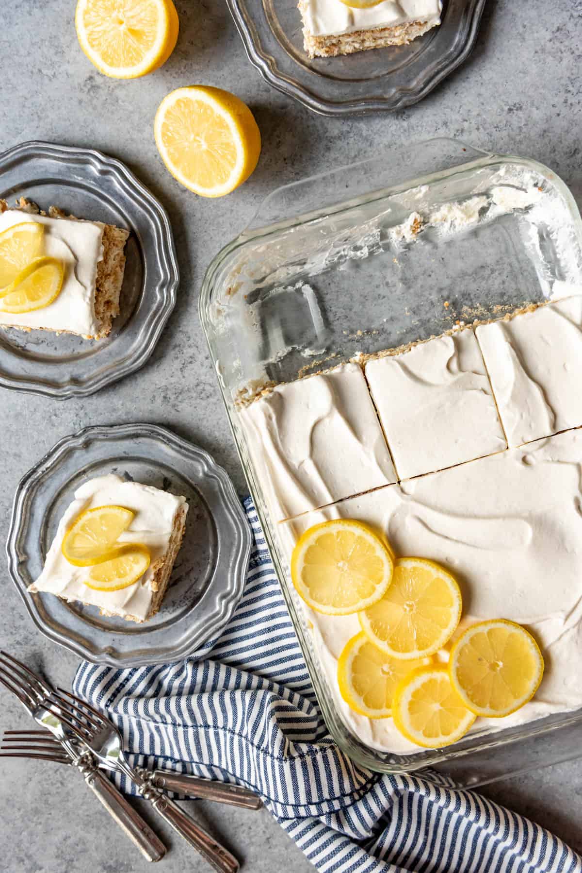 An image of a lemon icebox cake topped with whipped cream and decorated with lemon slices for garnish.