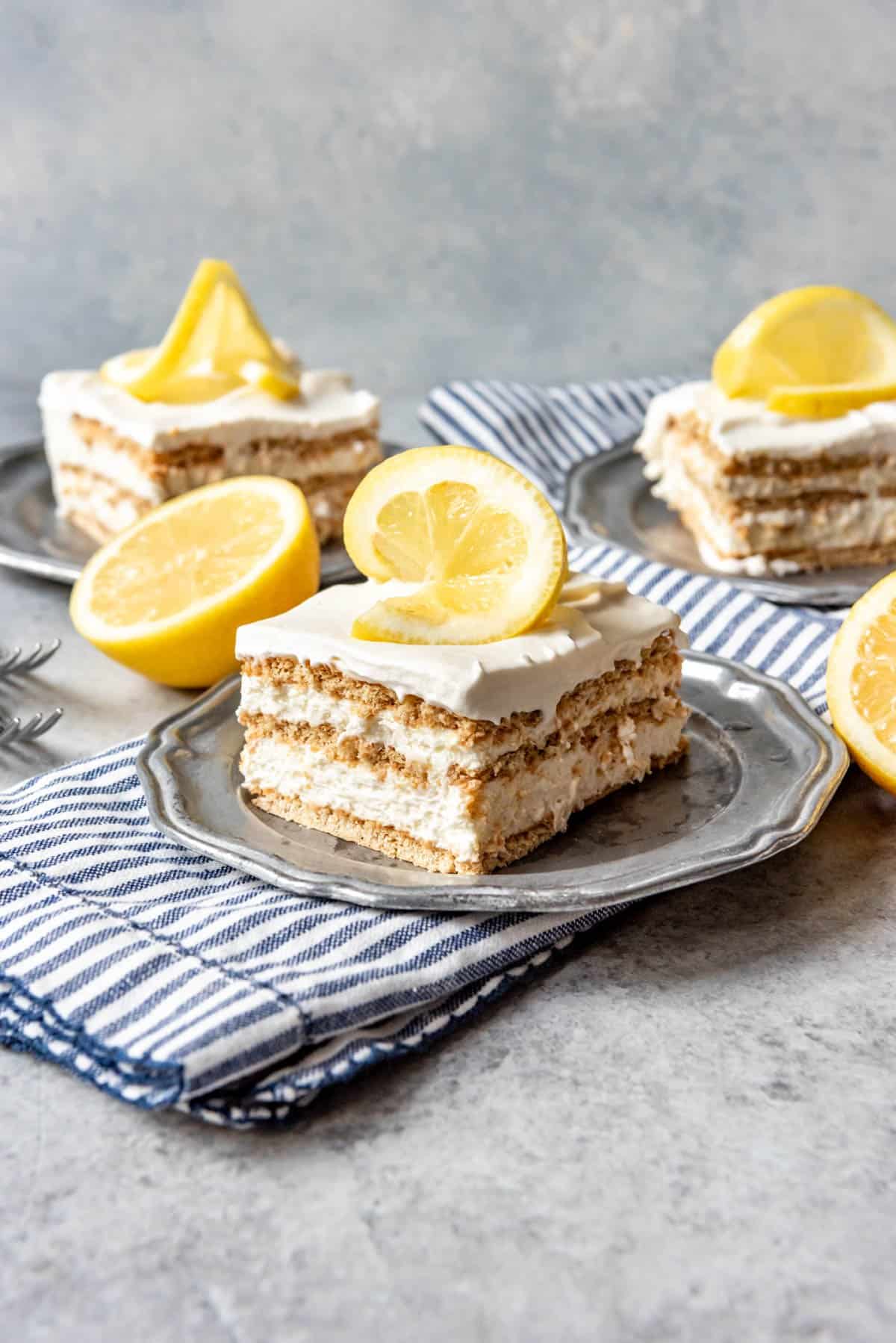 An image of a slice of lemon icebox cake on a pewter plate.