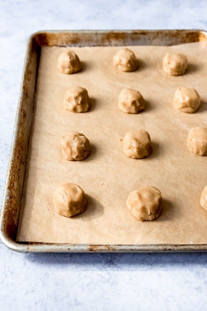 An image of balls of brown sugar cookie dough with dulce de leche stuffed inside.