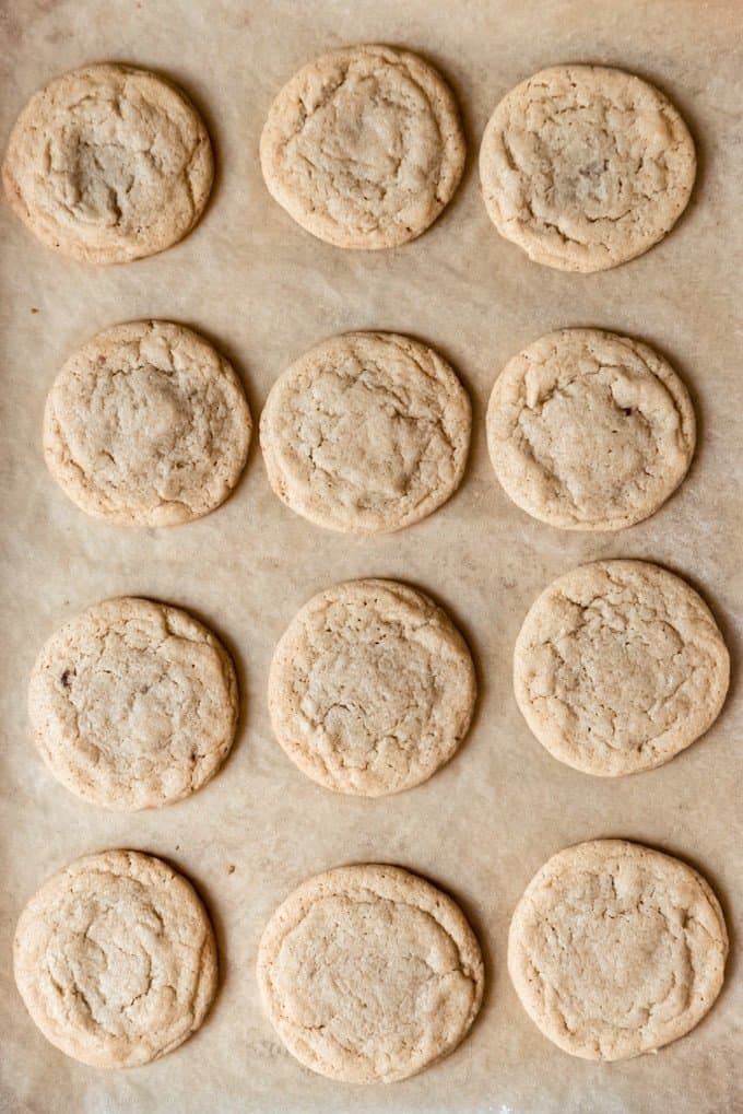 An image of dulce de leche stuffed cookies on parchment paper.