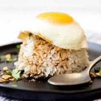 An image of sticky rice topped with soy glaze and a fried egg.