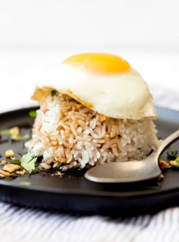 An image of sticky rice topped with soy glaze and a fried egg.