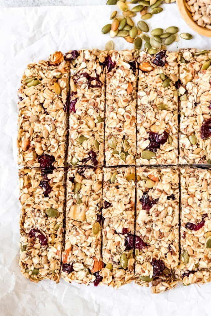 An image of a chewy homemade granola bar made with lots of fruit, seeds, and nuts, including chia, pumpkin, and sunflower seeds.
