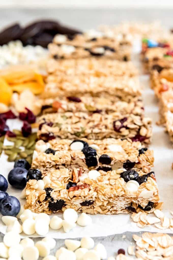 An side image of lemon blueberry white chocolate granola bars showcasing the tightly packed oats sweetened with honey and brown sugar and mixed with lemon zest, dried blueberries, pecans, and white chocolate chips.
