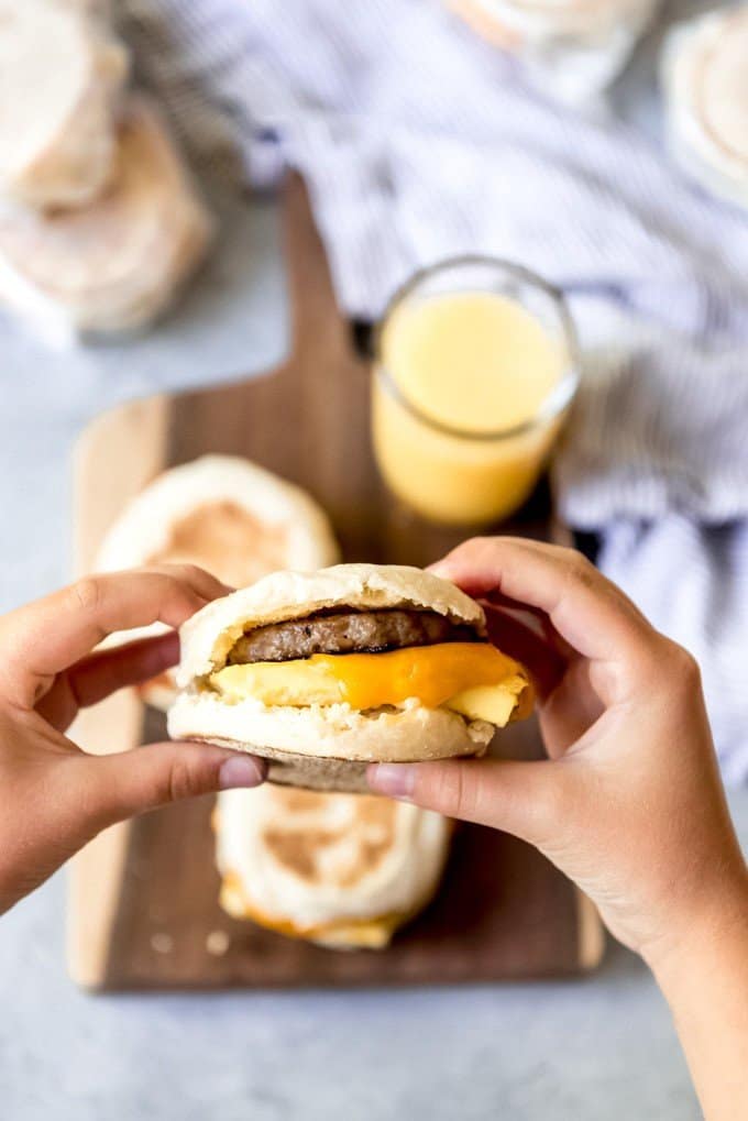 An image of a homemade sausage, egg, and cheese mcmuffin being held between two hands.
