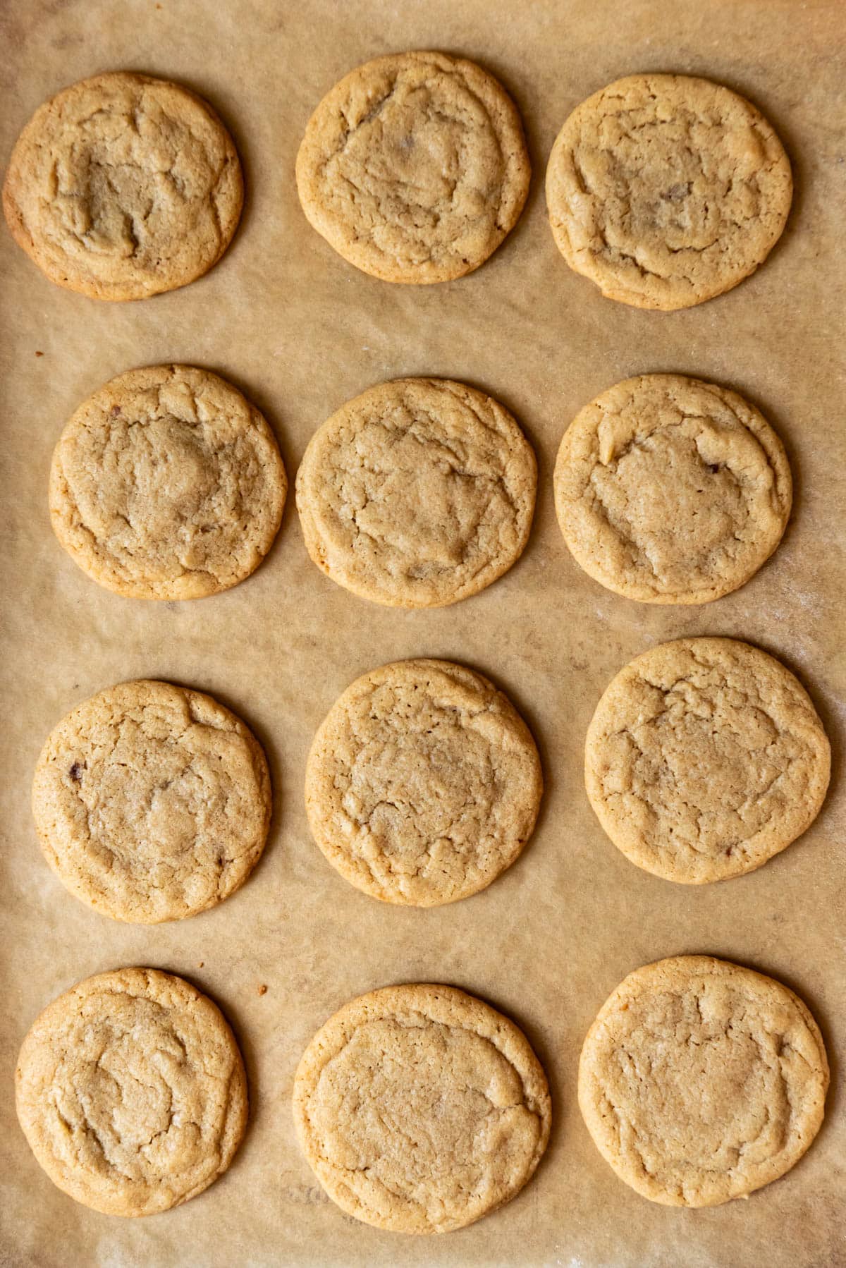 An image of dulce de leche stuffed cookies on parchment paper.