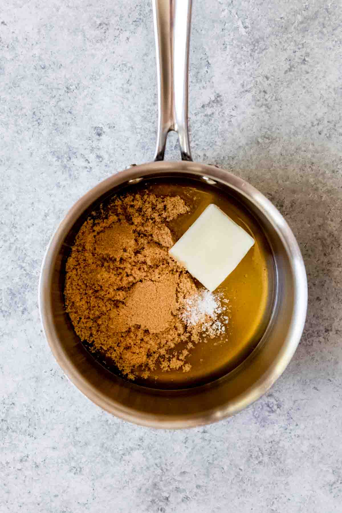 An image of a small saucepan with honey, brown sugar, butter, and salt in it to make the binding agent for homemade granola bars.