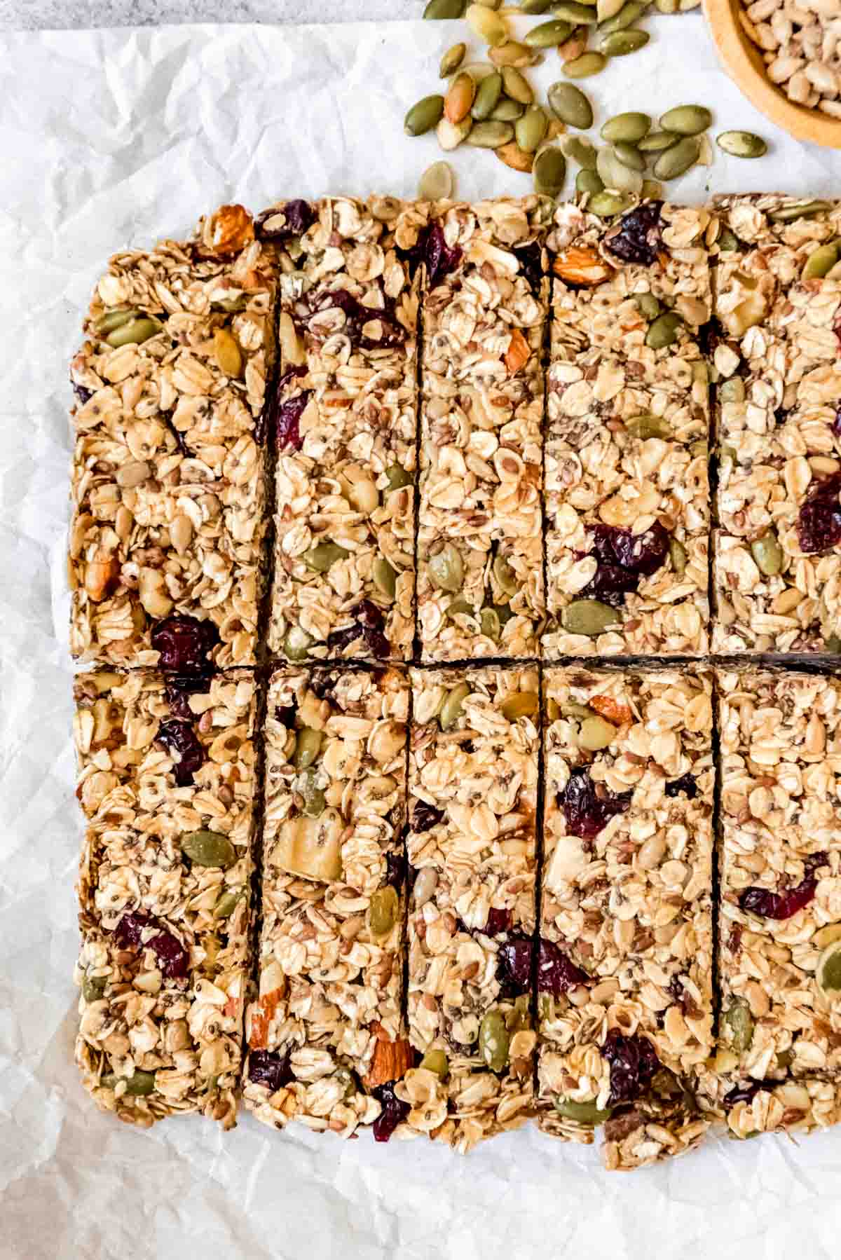 An image of a chewy homemade granola bar made with lots of fruit, seeds, and nuts, including chia, pumpkin, and sunflower seeds.