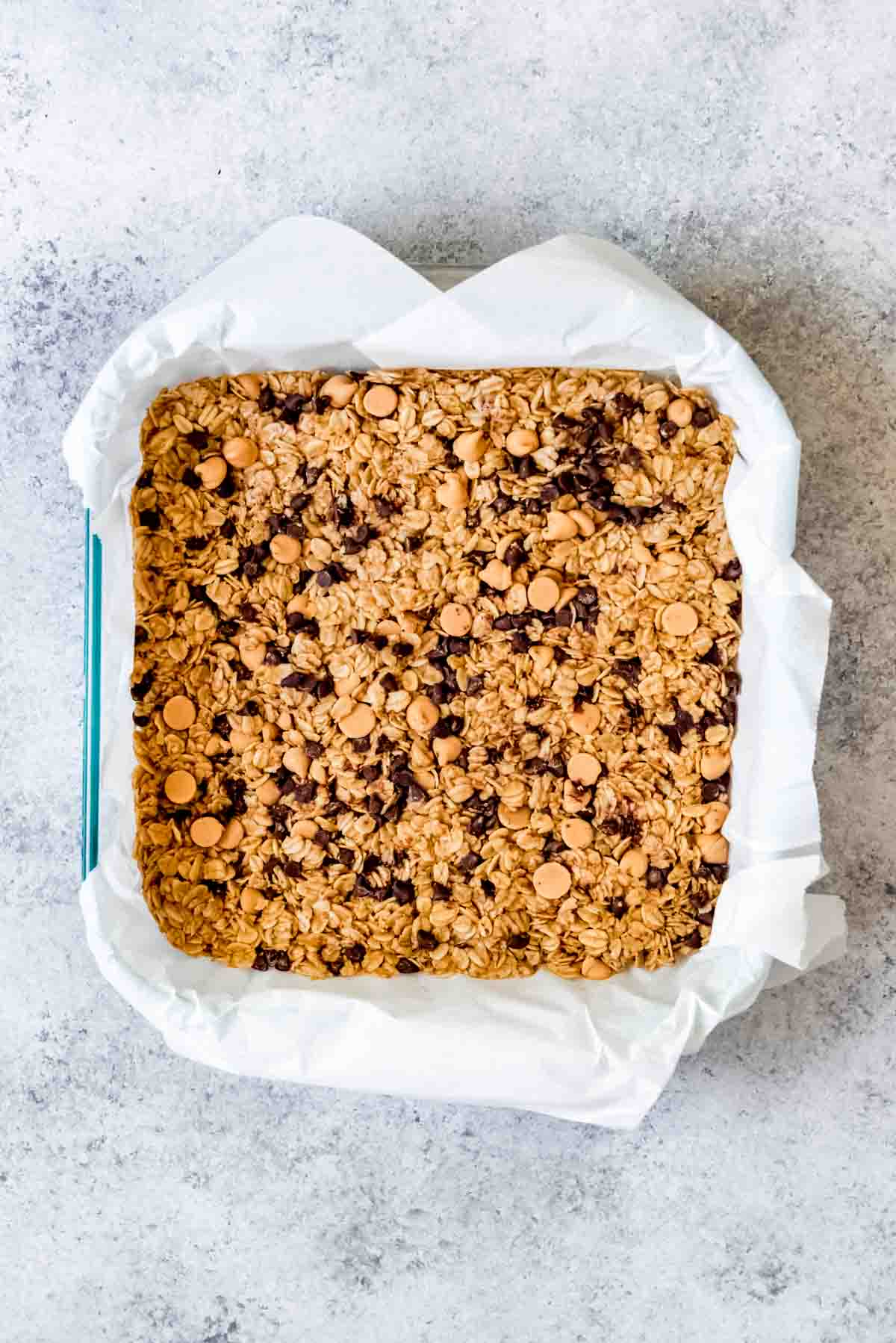 An image of a pan of chewy chocolate chip peanut butter granola before being sliced into bars.