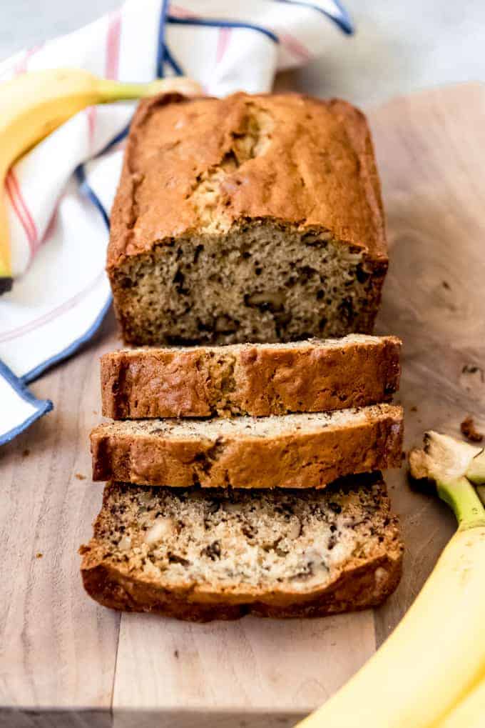 An image of a loaf of fresh, moist banana bread on a cutting board.