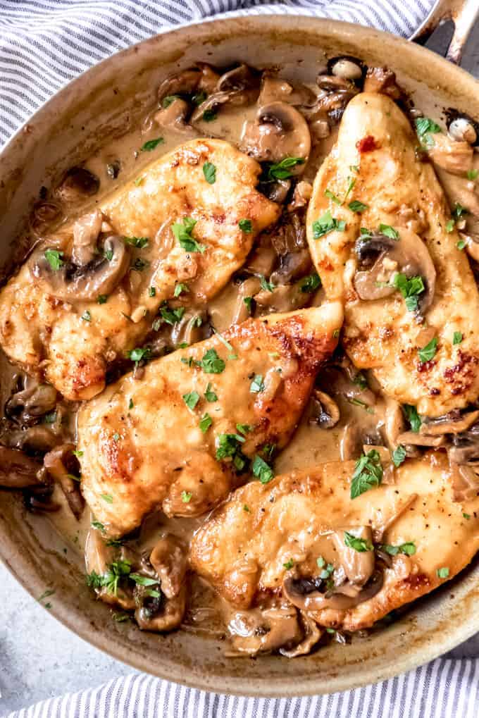 An image of four chicken breasts in a pan with a creamy marsala sauce.