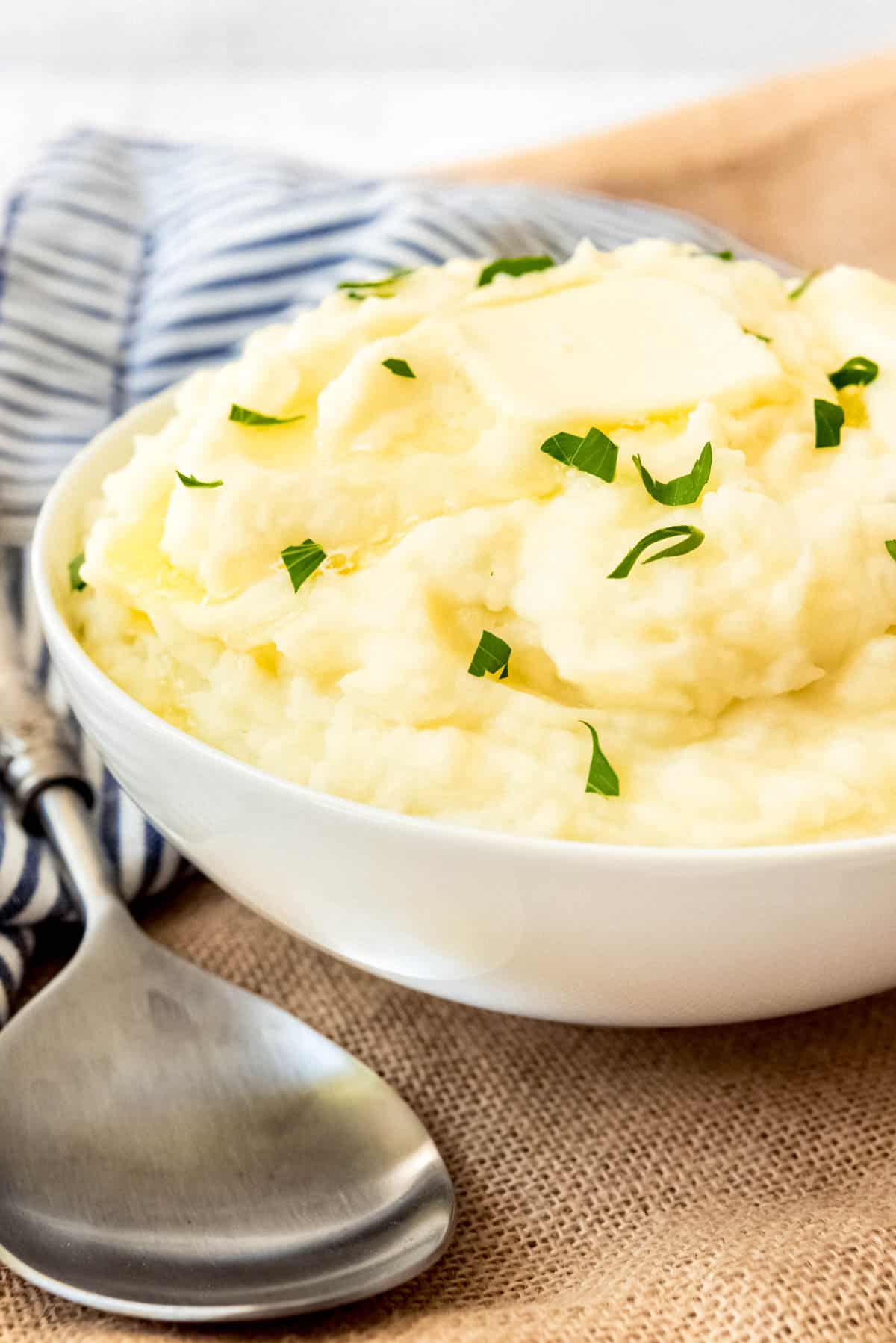 A bowl of creamy mashed potatoes with a pat of butter on top.