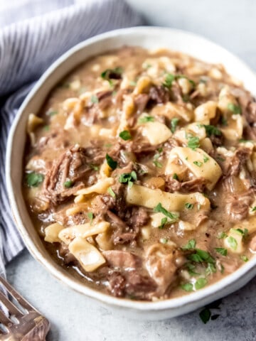 An image of homemade slow cooker beef and noodles in a bowl.