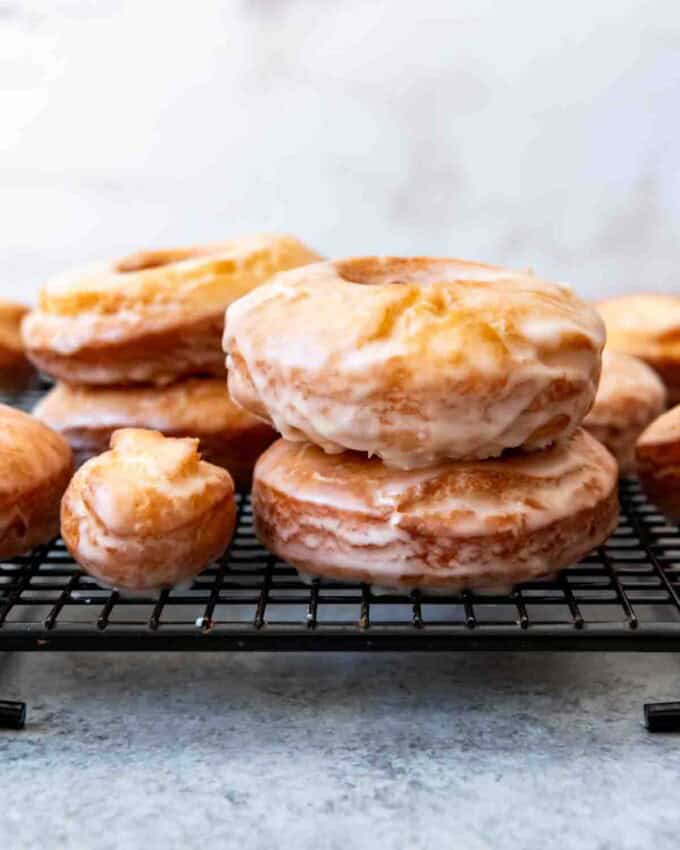 An image of glazed old-fashioned donuts stacked on top of each other.