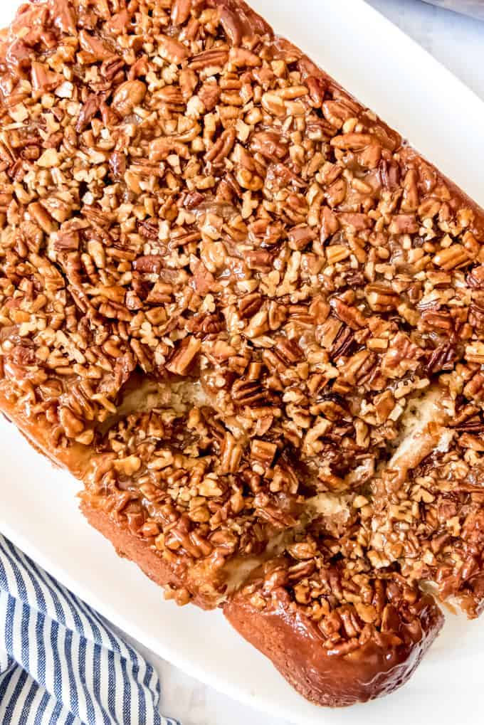 An image of caramel pecan sticky buns that have been turned over onto a serving plate so that the pecans are showing on top.