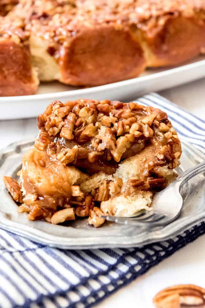 An image of a caramel pecan roll on a plate.