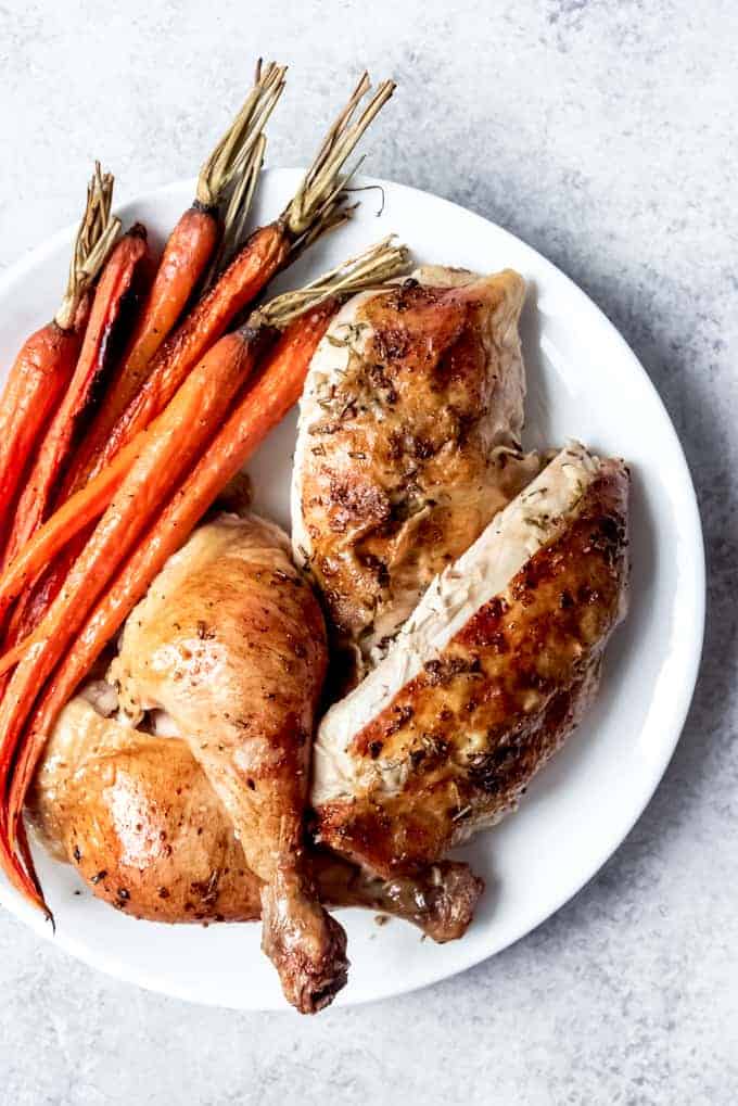 slow roasted chicken cut up with carrots on white plate