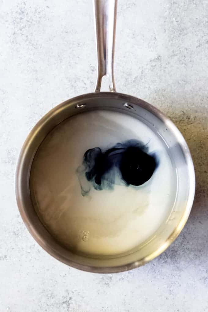 An image of a pan with sugar, corn syrup, water, and black food coloring.