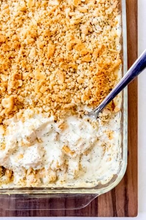 An image of poppy seed chicken casserole with a creamy sauce and Ritz cracker topping.