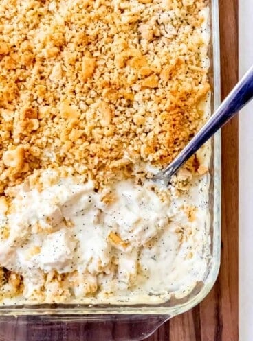 An image of poppy seed chicken casserole with a creamy sauce and Ritz cracker topping.