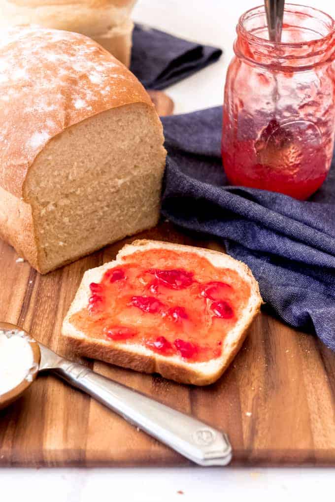 A piece of homemade bread with strawberry jam on it.