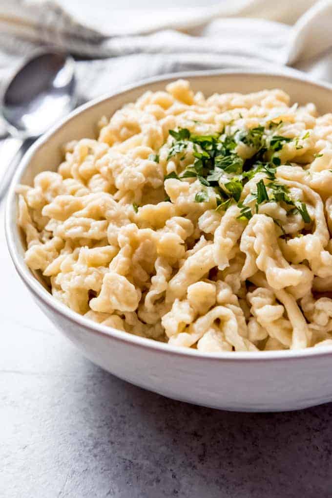 An image of a bowl of homemade German spaetzle with parsley on top.