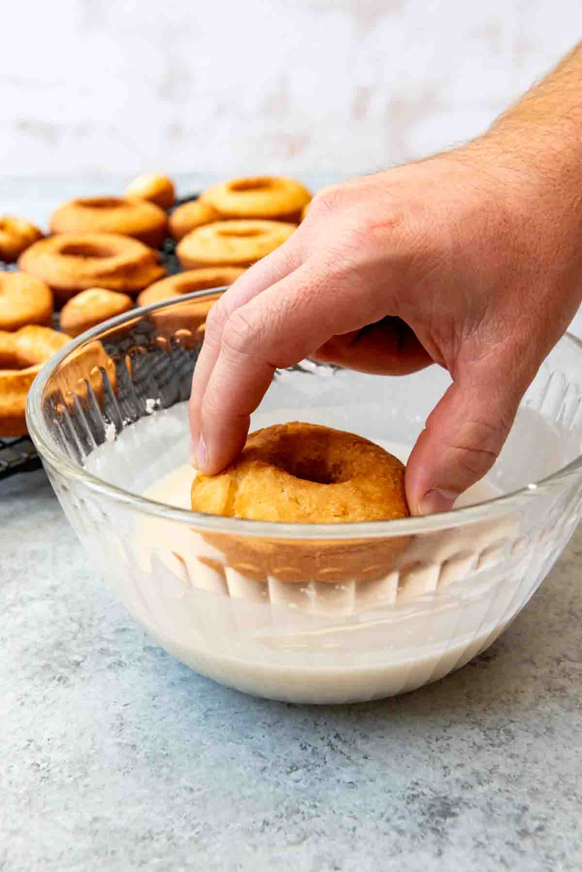 Dipping doughnuts in glaze.