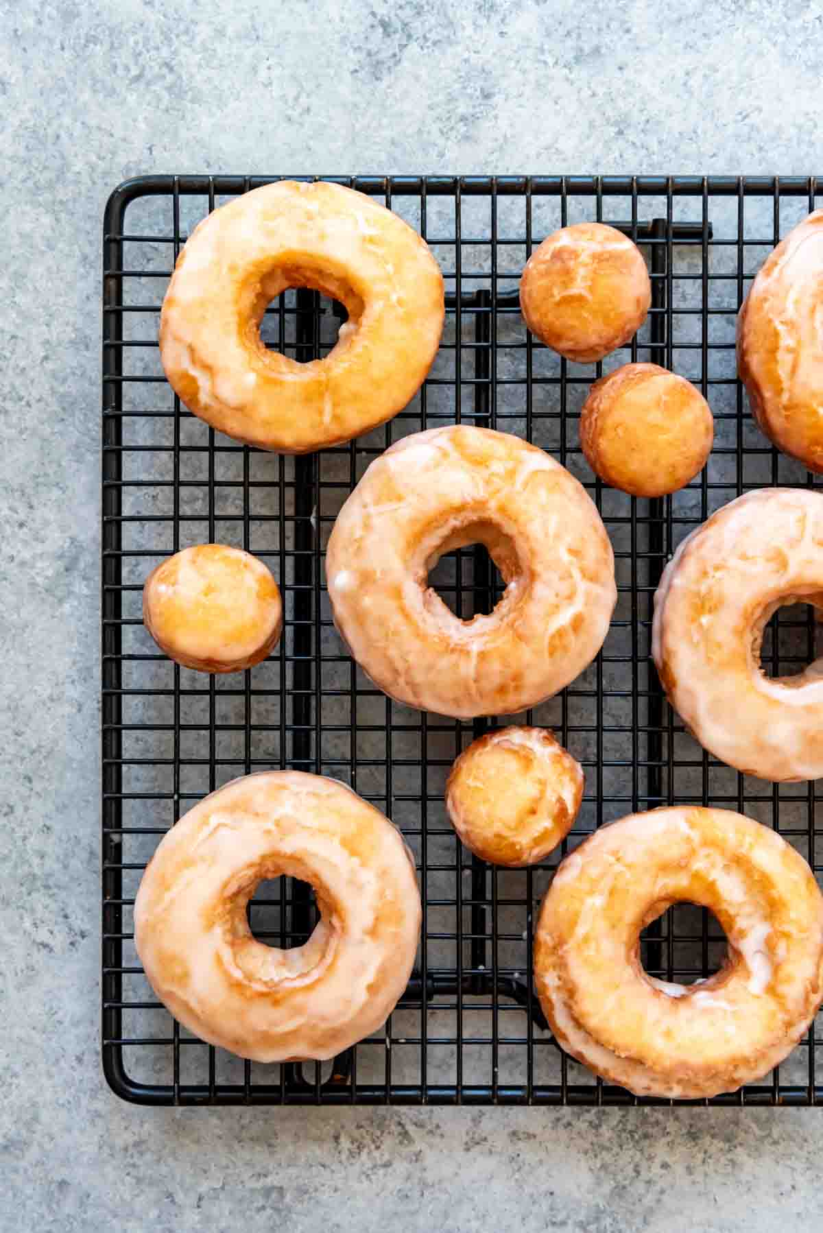 An image of old-fashioned sour cream doughnuts on a cooling rack.